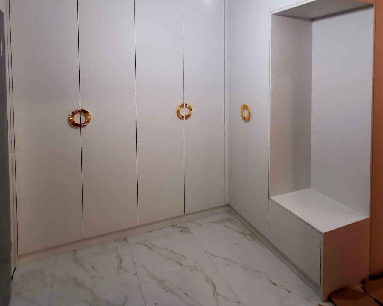 Gustowna biała garderoba ze złotymi rączkami